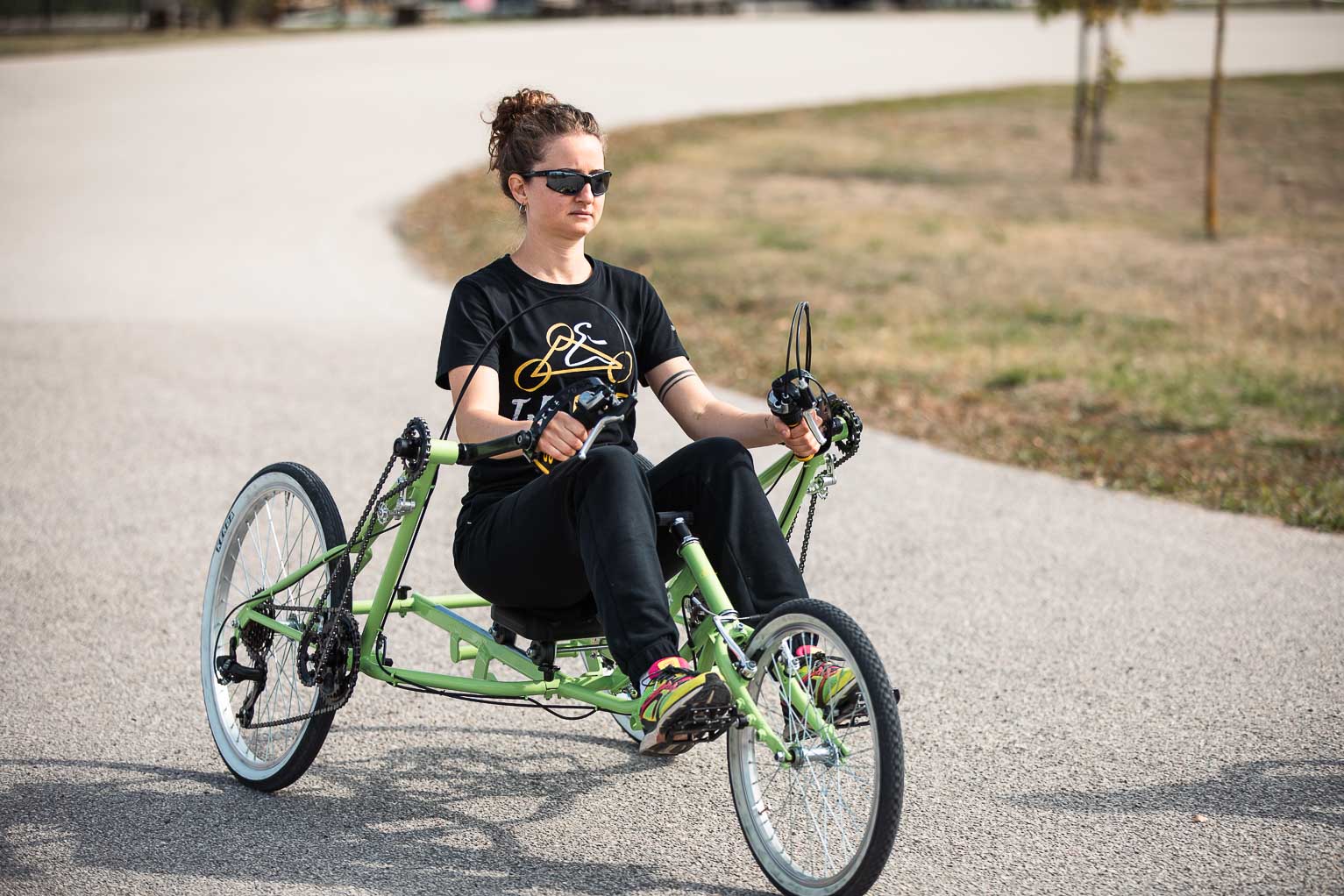 Ragazza che pedala con le braccia su T.B. Bike verde