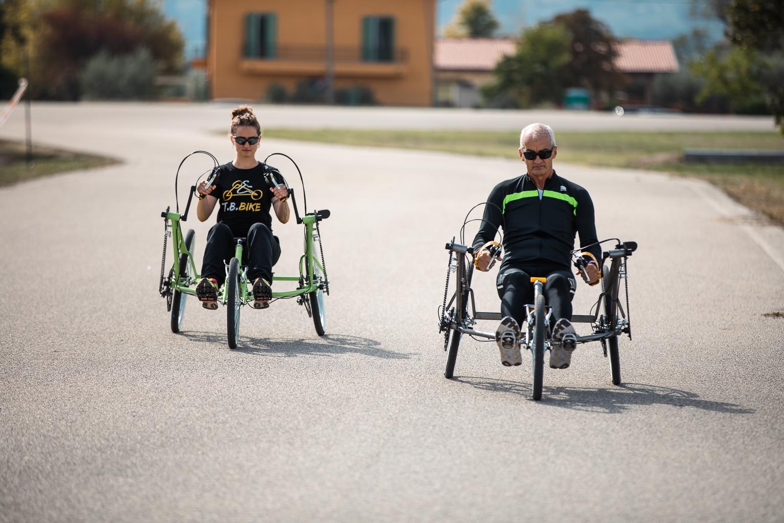 Due persone partono affiancate su T.B. Bike verde e grigia
