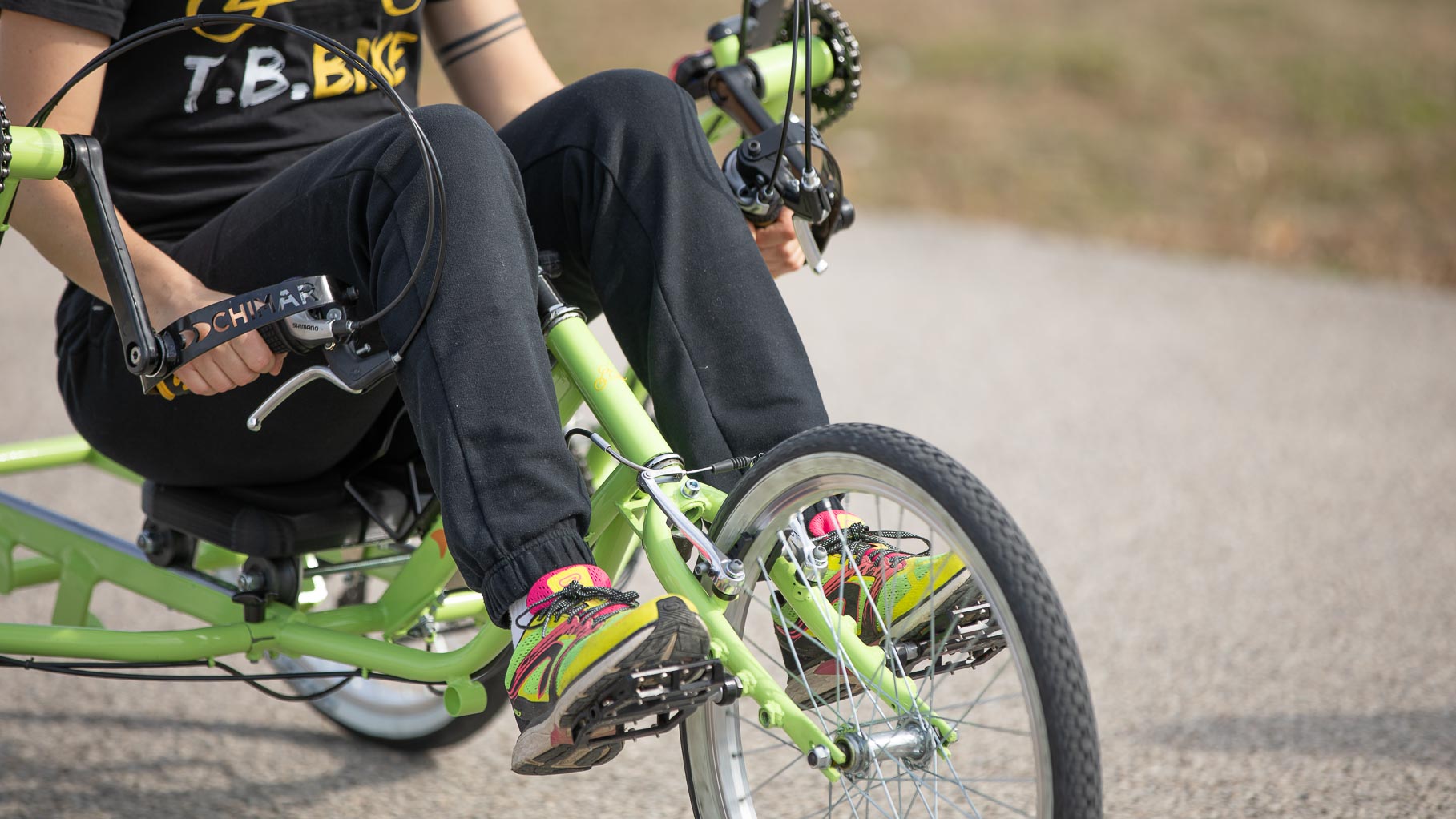Piedi sui pedali dello sterzo di T.B. Bike verde